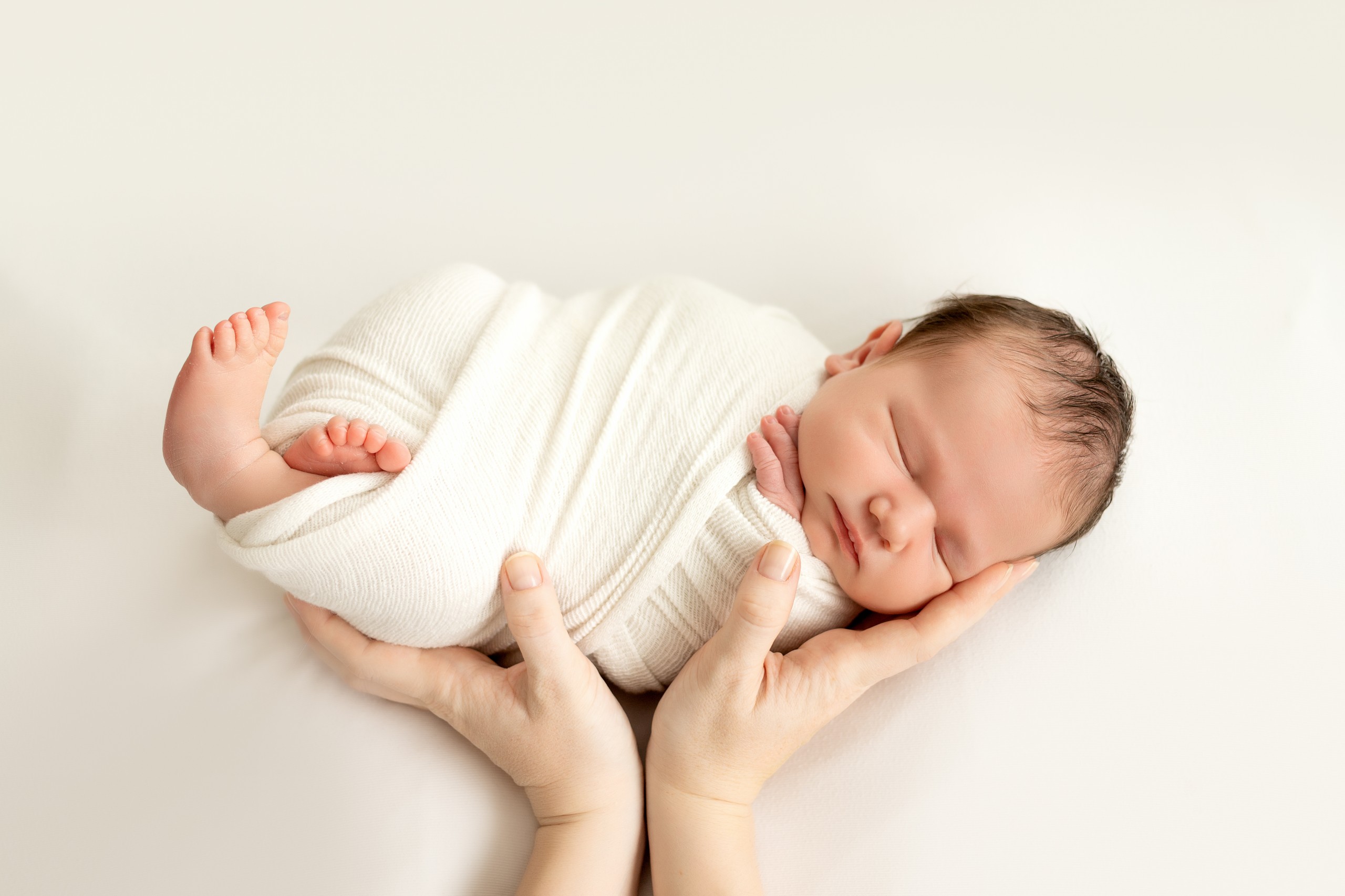 sleeping new born baby wrapped in a knit blanket
